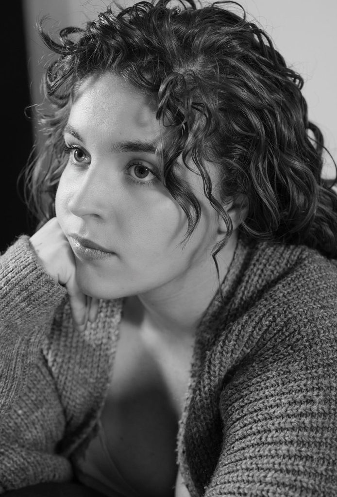 Vrouw met gezonde glanzende krullen na juiste verzorging en styling met crème